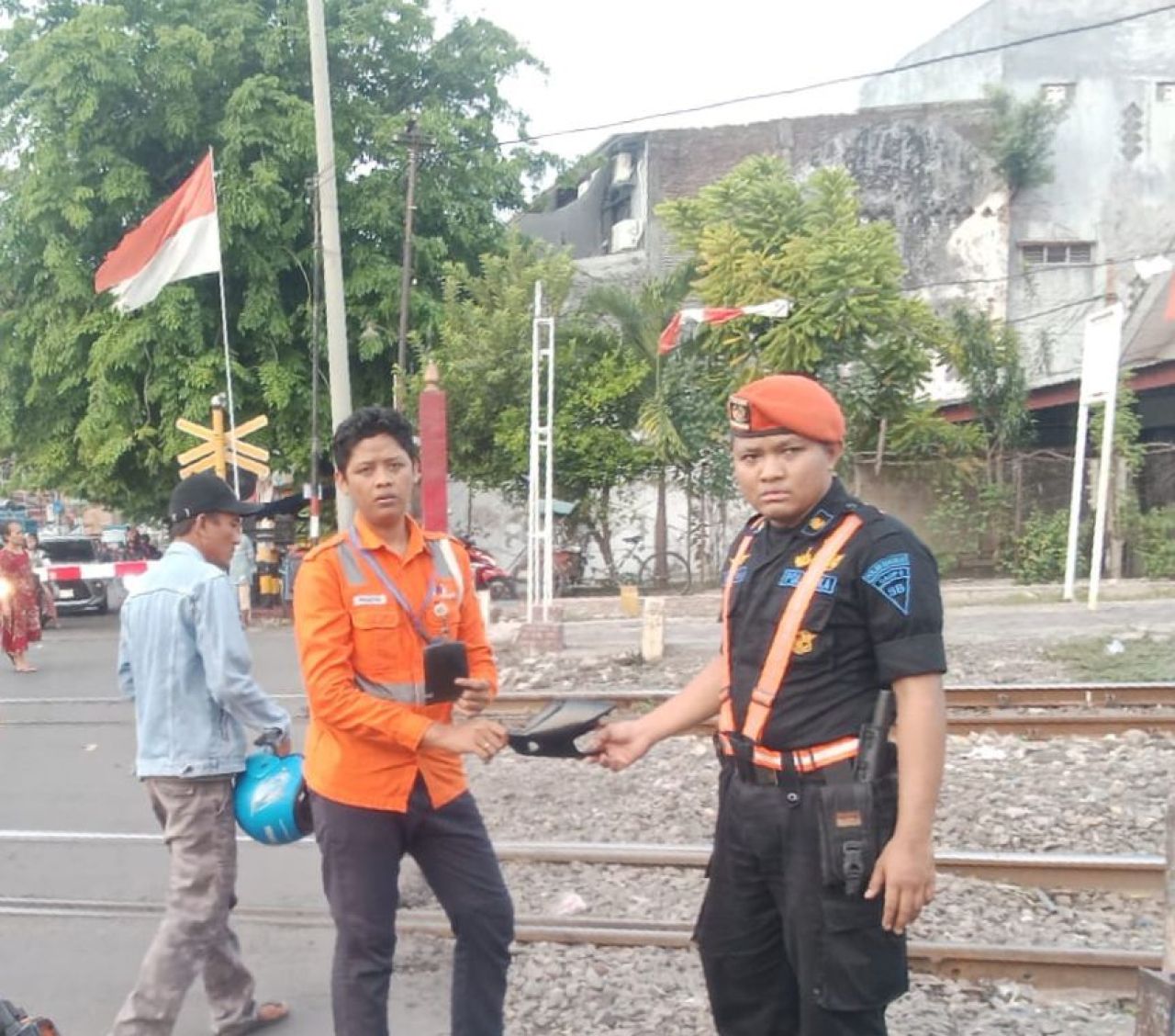 Petugas KAI palang pintu perlintasan Commuterline