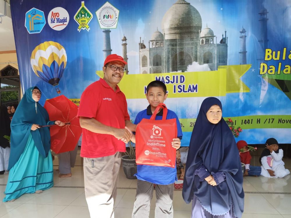 Perwakilan Telkom Jatim Bali Nusra sekaligus jemaah Masjid Nurul Islam menyerahkan hadiah kepada peserta. 