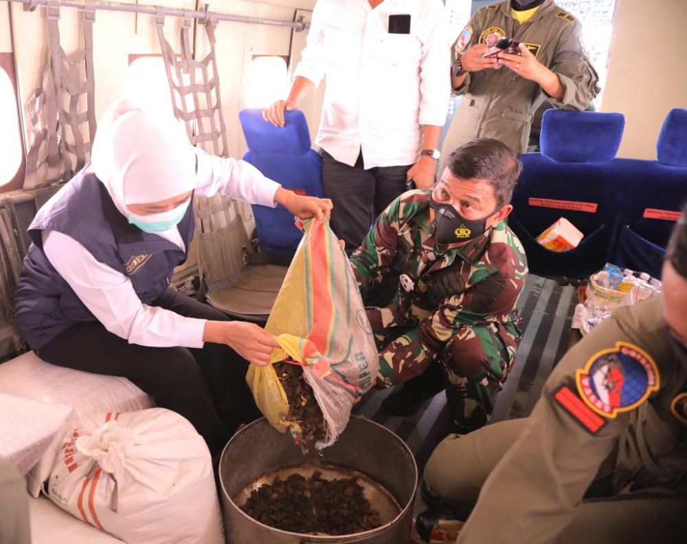 Gubernur Jatim Khofifah sedang menuang benih untuk disebarkan 