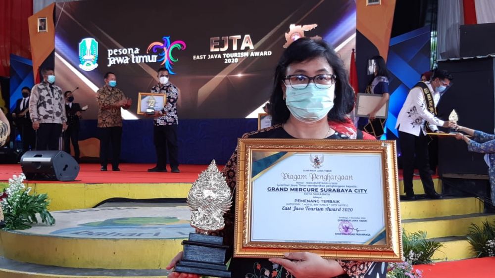 Menerima penghargaan Eksi Ayuningtyas- General Manager Grand Mercure Surabaya City