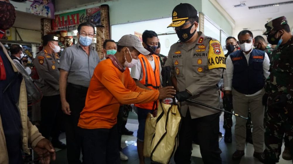 Kapolda Jatim Irjen Pol Dr. Nico Afinta sedang membagikan masker