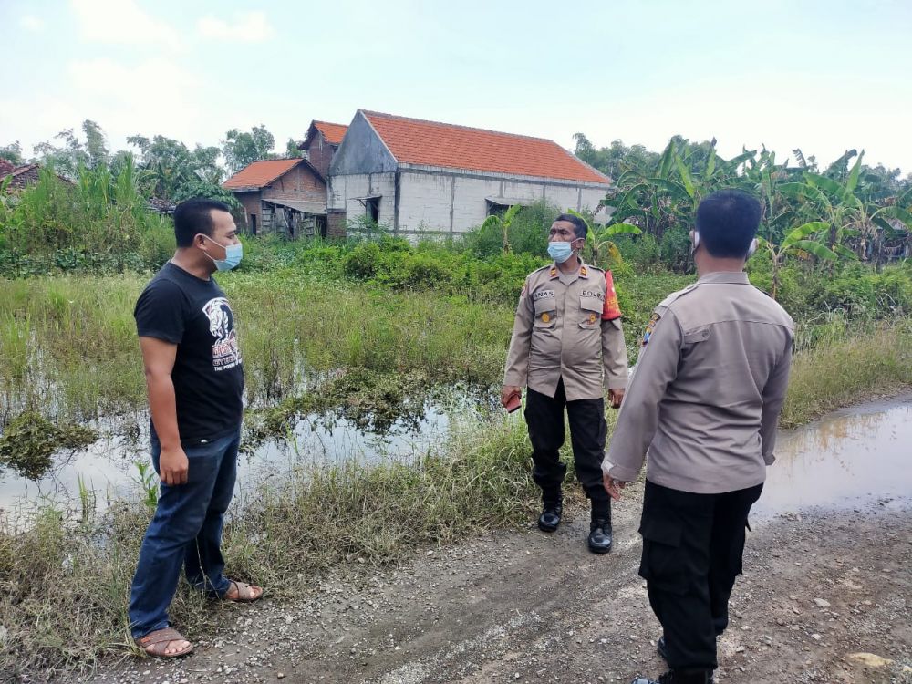 Wakapolsek Kedamean Iptu Anas Tohari bersama Kasi Humas Aipda Febrianto N melihat rumah warga terdampak banjir