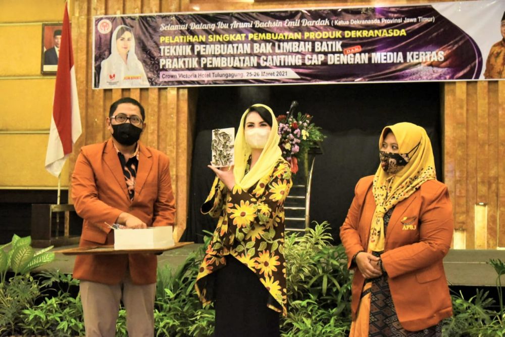 Arumi Bachsin sedang menunjukkan hasil karya pengrajin batik