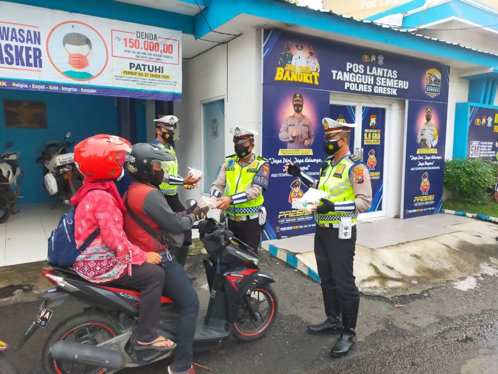 Anggota Satlantas Polres Gresik berbagi nasi bungkus ke R2 dan pemakai jalan