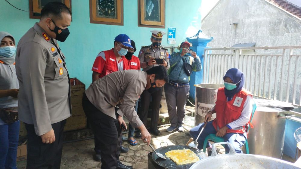 Kapolda Jatim Irjen Pol Dr Nico Afinta saat bantu relawan di dapur umum dengan menggoreng telor