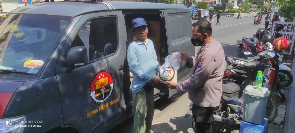 Anggota Polres Gresik saat membagikan paket Sembako