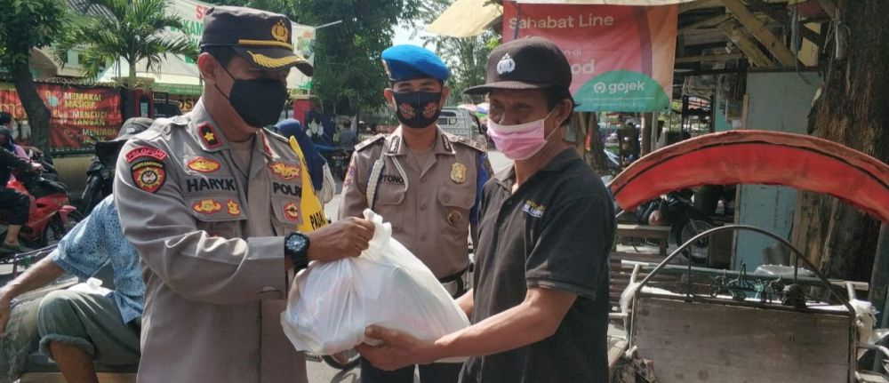 Kapolsek Asemrowo Kompol Hari Kurniawan berbagi Sembako pada tukang becak dan kuli panggul di pasar Surya