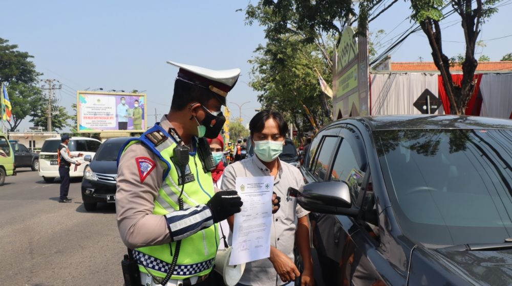 Anggota Polres Gresik saat lakukan pengamanan cegah penyebaran Covid-19 di pos check poin penyekatan