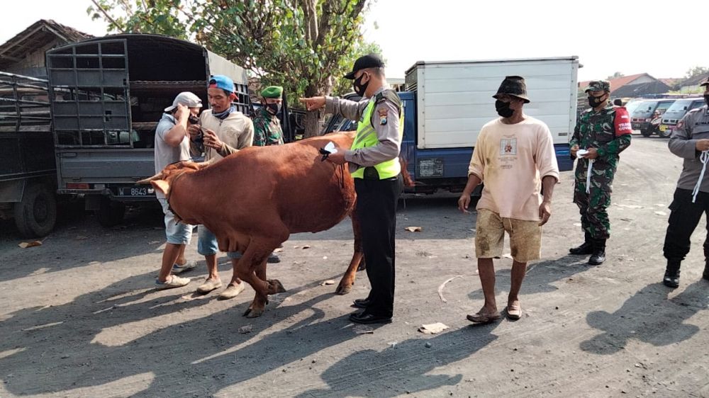 Anggota Polsek Balongpanggang saat menyasar pasar hewan terus edukasi Prokes