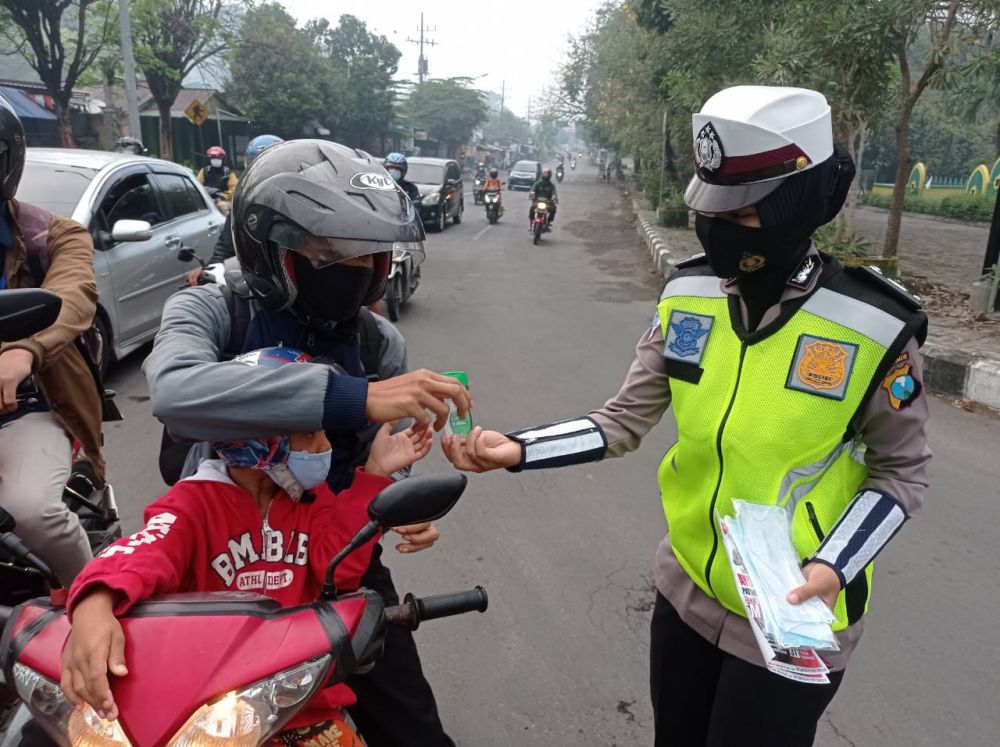 Polwan Polres Gresik saat berbagi Handsanitizer pada pengendara yang lewat