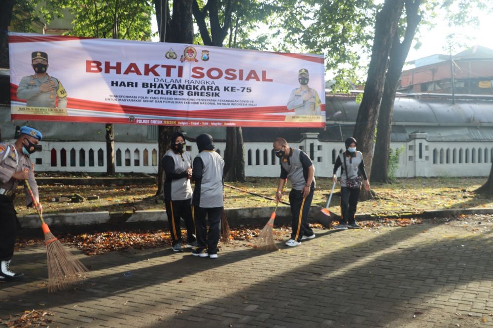 Kapolres Gresik dan jajarannya saat melakukan bersih-bersih di taman makam Pahlawan