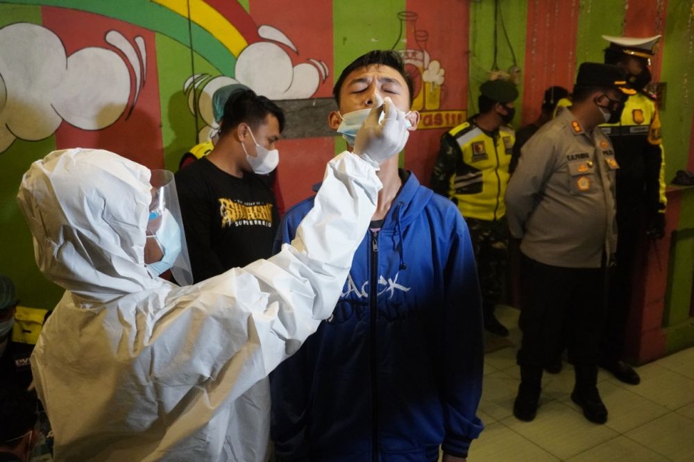 Petugas saat membubarkan pengunjung Warkop yang akan di Swab Antigen terlebih dahulu