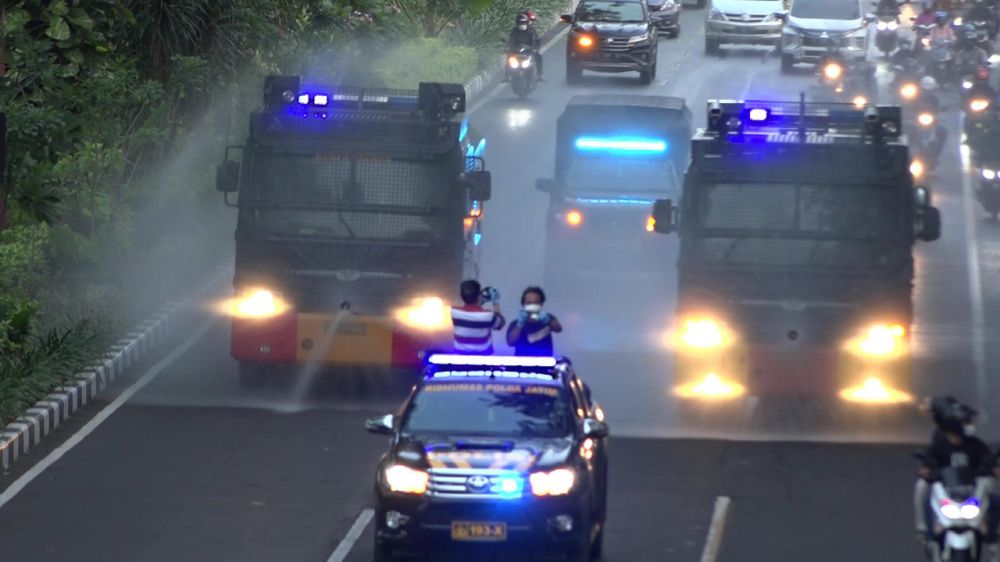 Satbrimob Polda Jatim dan mobil Gegana Dekontaminasi kimia biologi radioaktif saat lakukan penyemprotan Disinfektan di seluruh Kota Surabaya