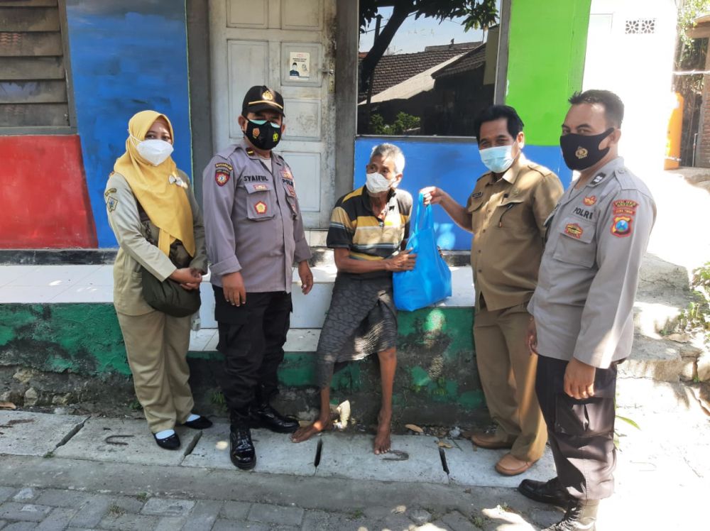 KBO Binmas Iptu Syaiful Bakri bersama anggota Polres Gresik memberikan bantuan kepada korban pandemi Covid-19
