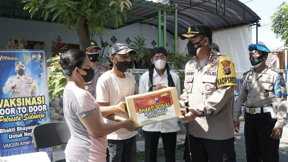 Kapolresta Sidoarjo Kombes Pol Kusumo Wahyu Bintoro saat berbagi sembako ke warga terdampak pandemi Covid-19