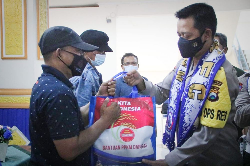 Kapolres Malang AKBP Bagoes Wibisono saat memberikan paket sembako kepada suporter Aremania Malang yang terdampak Covid-19 dan PPKM Darurat