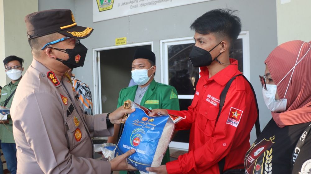 Kapolres Gresik AKBP Arief Fitrianto saat memberikan paket sembako kepada warga yang selesai di suntik vaksin