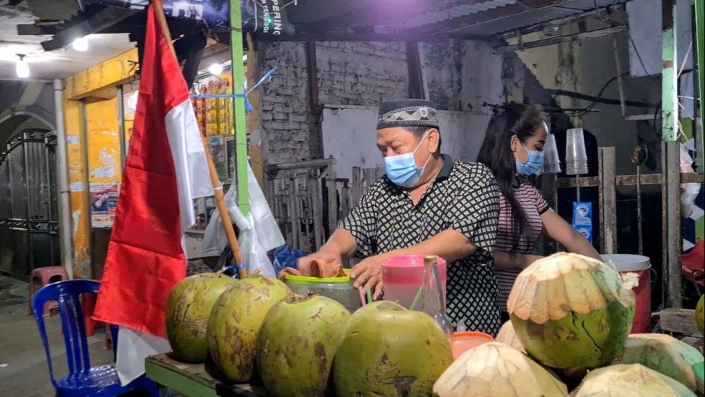 Para pedagang dengan semangat membara mengibarkan bendera Merah Putih lawan Covid-19 sambut hari Kemerdekaan RI ke-76