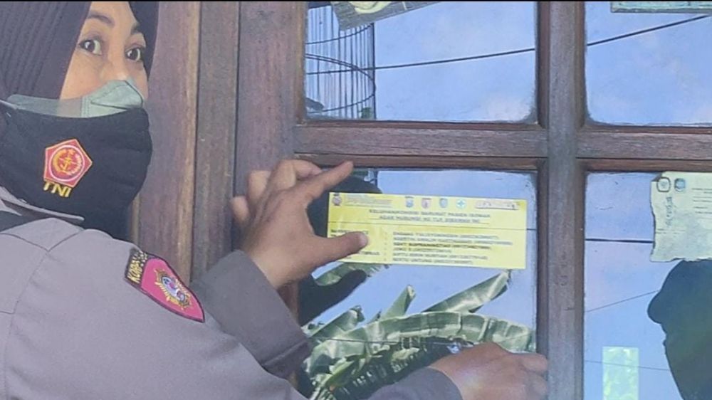 Polwan cantik Polres Banyuwangi sedang menempelkan stiker himbauan kepada masyarakat