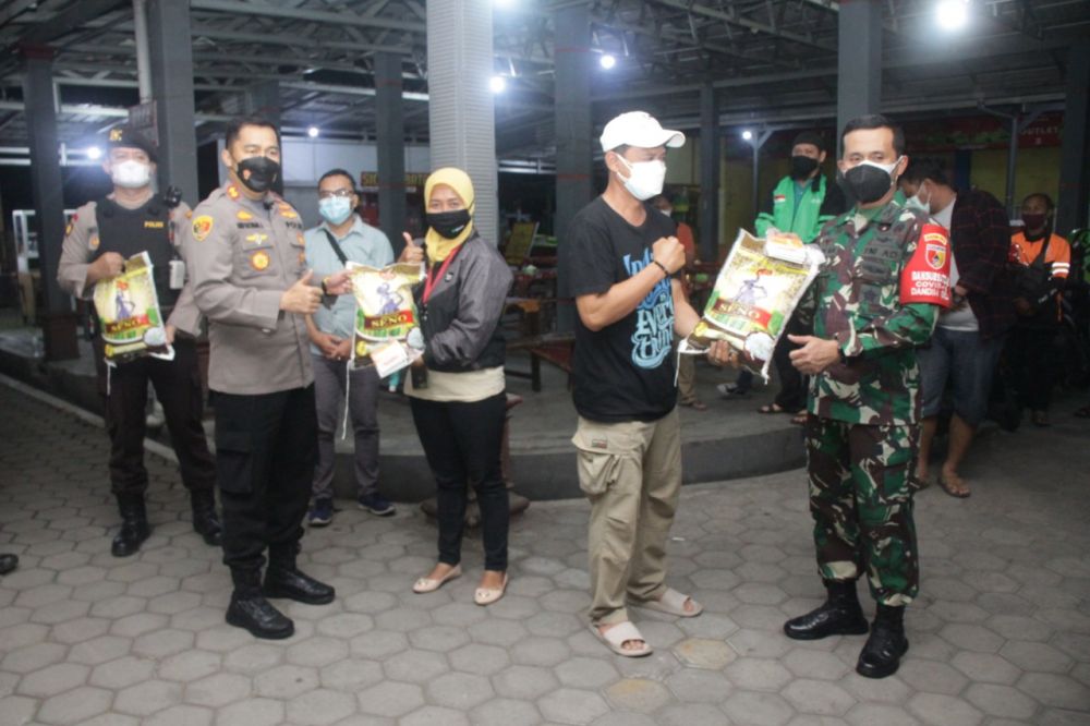 Kapolres Jember AKBP Arief Rachman Arifin bersama Dandim 0824 Jember Letkol Inf. Laode M. Noerdin saat memberikan paket sembako