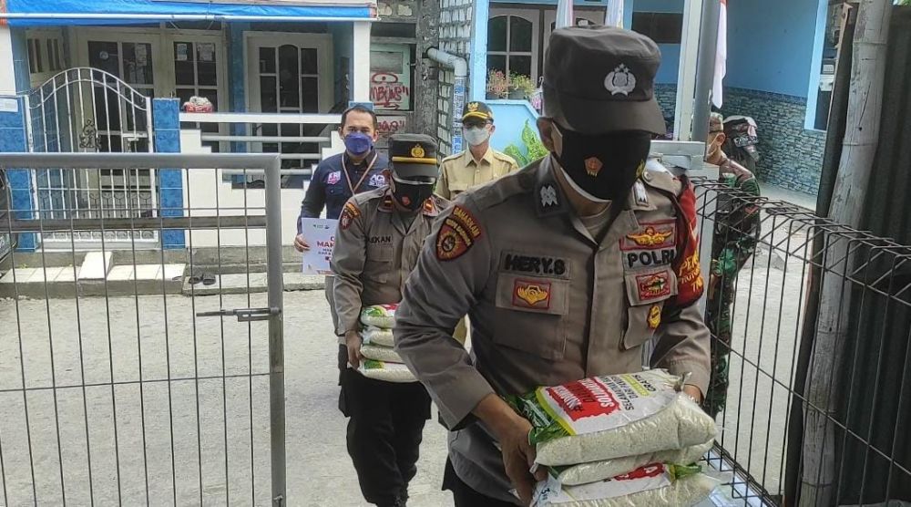 Relawan bersama Bhabinkamtibmas saat memberikan paket sembako kepada Mbah Ya Tripah