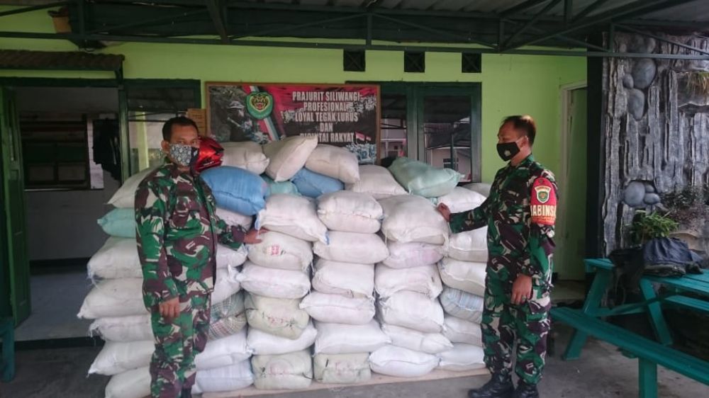 Foto Serka Darwin siringo ringo bersama-sama Koptu Budi Pramono sedang membetulkan posisi karung beras