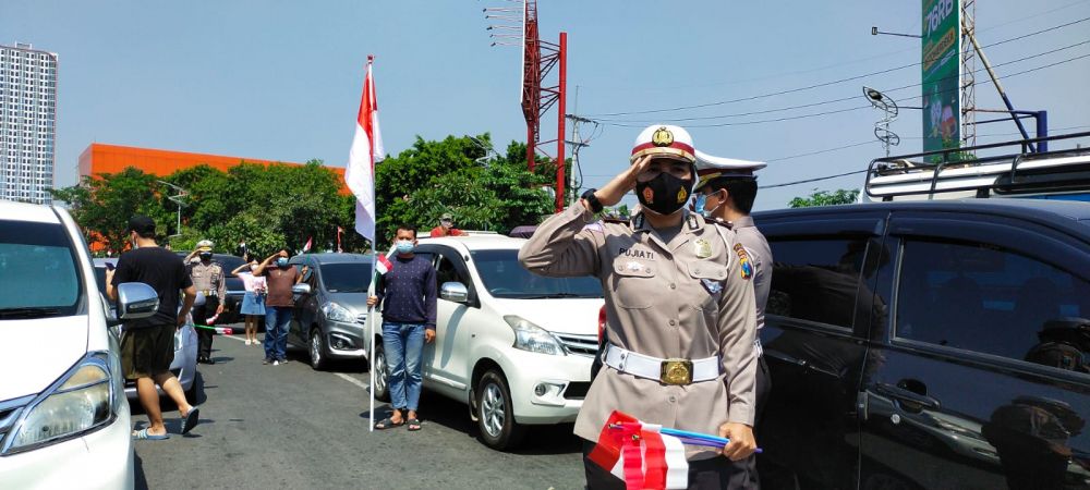 Kepolisian dan pengendara nyanyikan lagu Indonesia Raya sambil membawa bendera Merah Putih