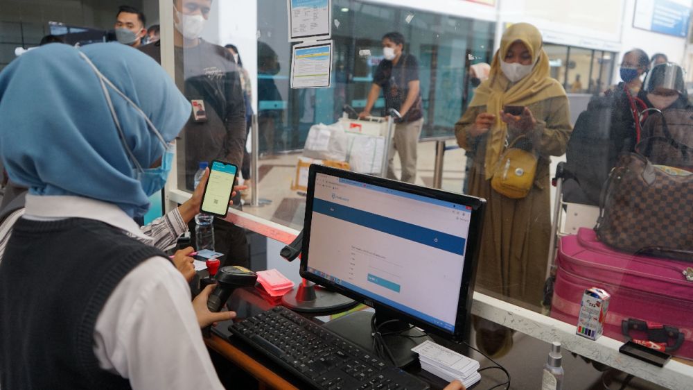 Petugas bandara saat cek aplikasi PeduliLindungi milik penumpang yang akan gunakan jasa pesawat