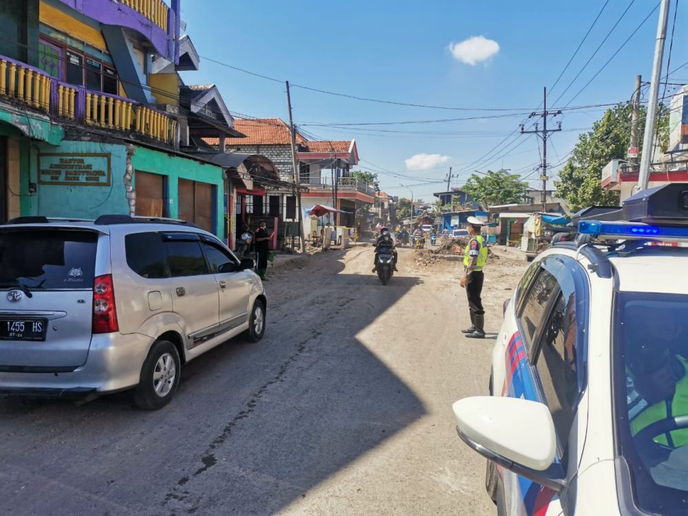 Polantas Polres Gresik saat turun untuk mengatur kelancaran jalan yang diperbaiki
