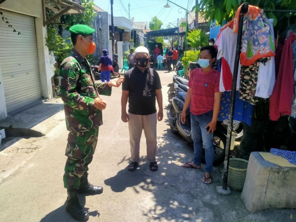 Babinsa Koramil 0817/01 Driyorejo saat sosialisasi ke warga terkait Covid-19