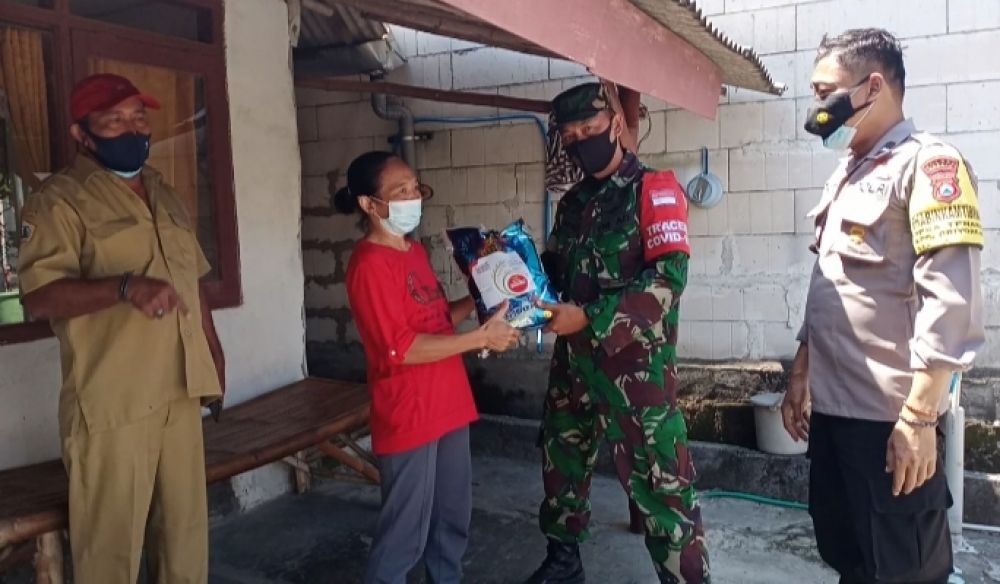 Anggota Koramil Driyorejo saat memberikan paket sembako kepada warga terdampak Covid-19
