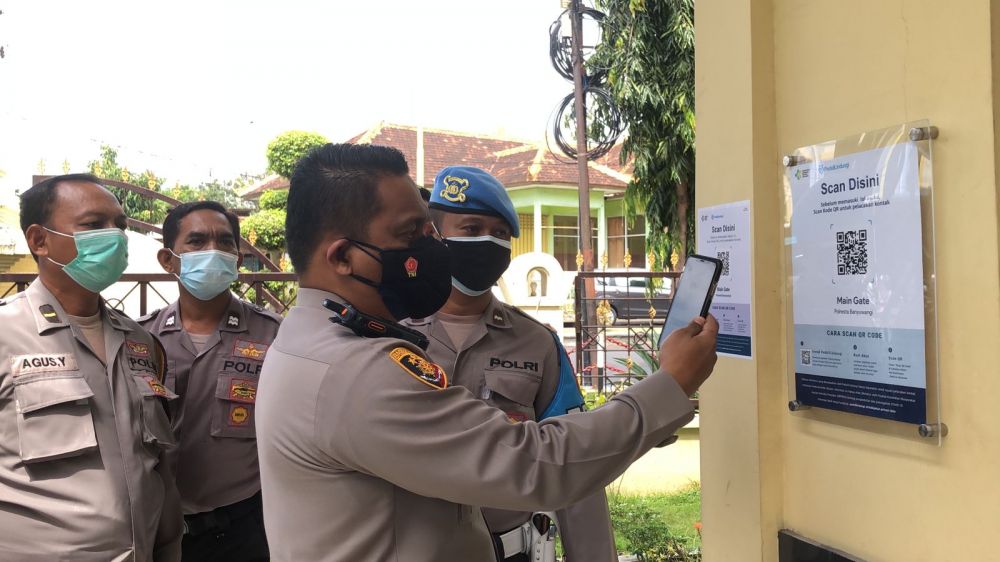Kapolres Banyuwangi AKBP Nasrun Pasaribu saat mencoba aplikasi PeduliLindungi di Mapolres Banyuwangi
