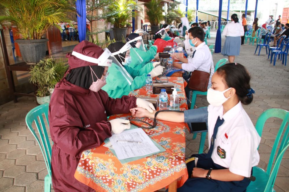 Para pelajar yang mengikuti antrian suntik vaksin