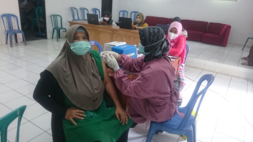 Tampak petugas vaksinator dari Puskesmas Hariang, sedang menyuntikkan vaksin Dosis 2 sinovac ke pasien yang pertama