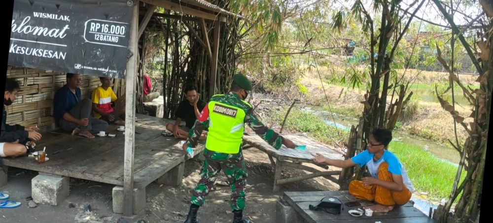 Serma Marwi saat sosialisasi Prokes dan bagikan masker ke pengunjung warkop