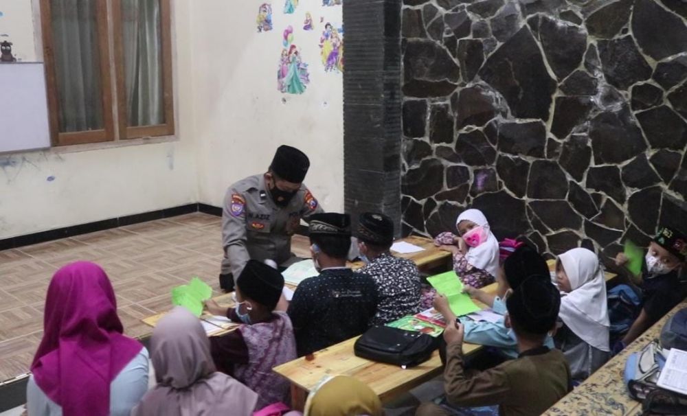 Aipda Nurkholis Azis saat mengajar ngaji anak-anak