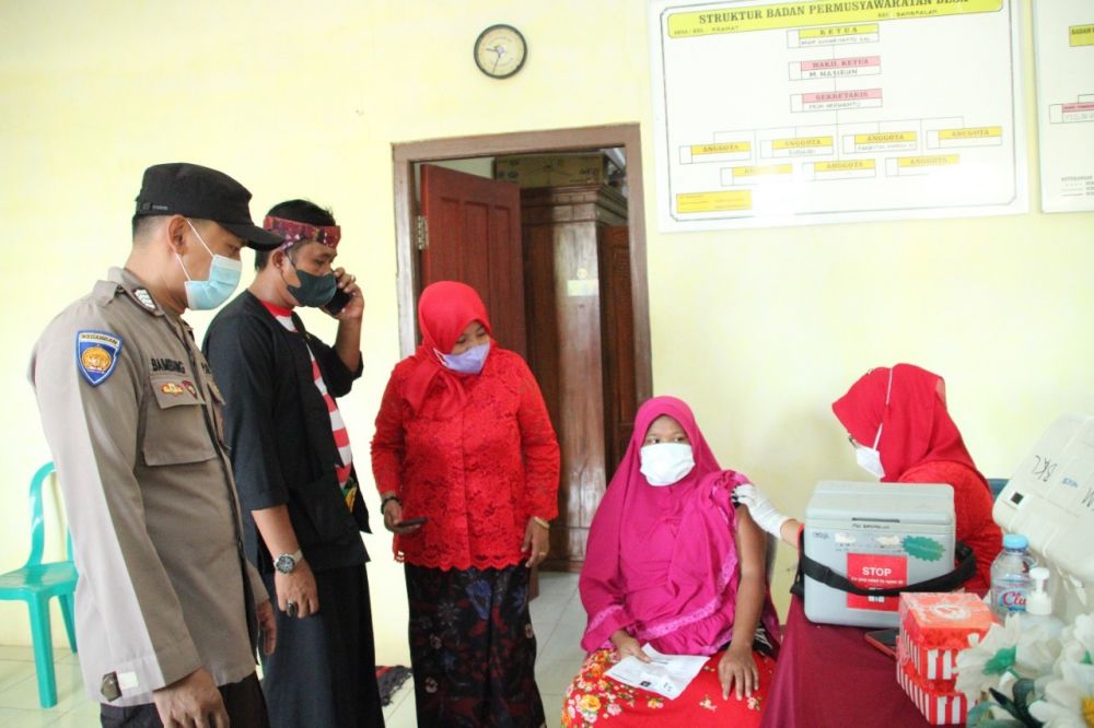 Kasi Humas Polres Bangkalan bersama Nakes dan perangkat desa keliling suntik vaksin