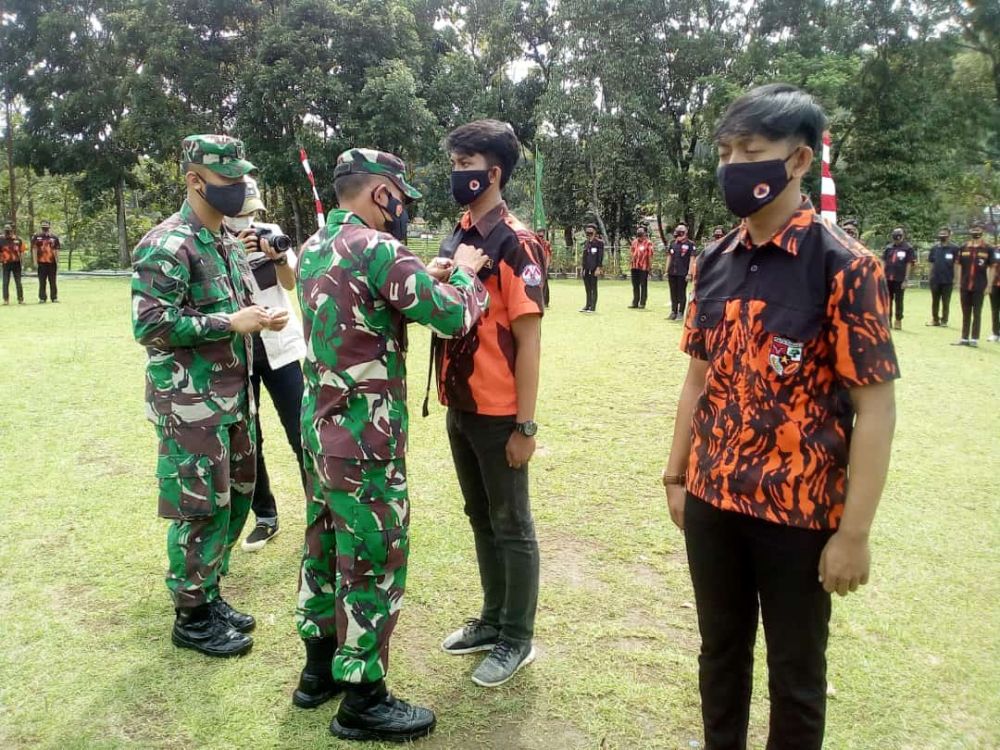 Dandim 0610 Letkol. Inf. Zaenal Mustofa S.E. M.Si., sedang memasang penyematan tanda peserta kepada para Kader Pratama Sapma Pemuda Pancasila seusai sambutannya di Makodim 0610/Sumedang