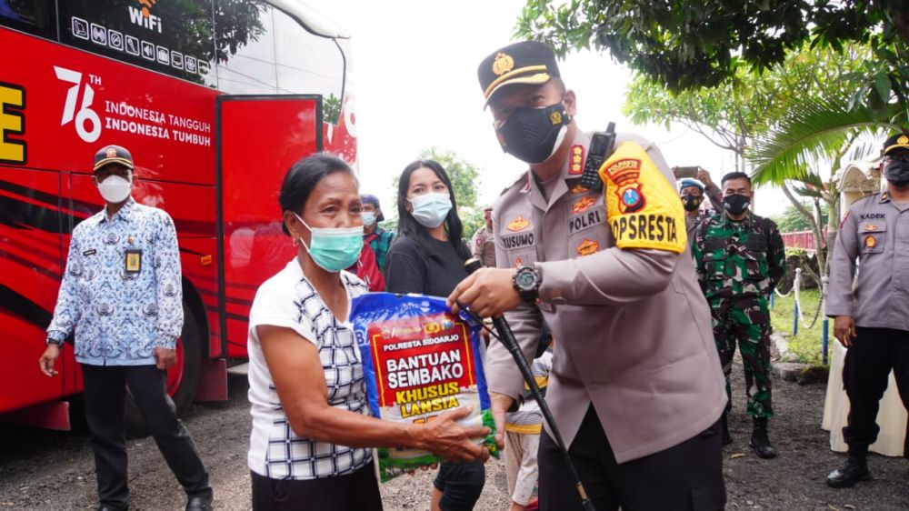 Kapolresta Sidoarjo Kombes Pol Kusumo Wahyu Bintoro saat memberikan paket sembako kepada warga