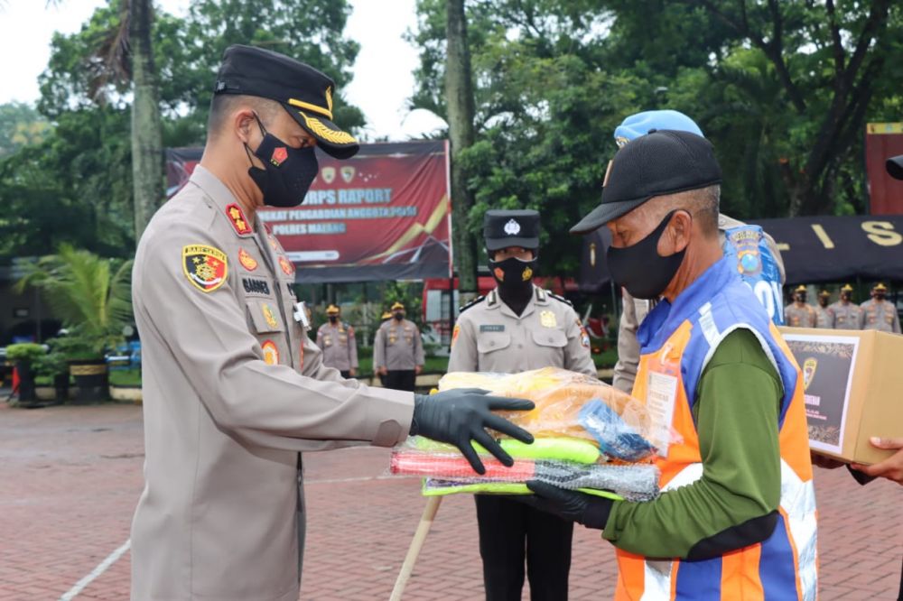 Kapolres Malang AKBP Bagoes Wibisono saat memberikan penghargaan kepada penjaga rel KA Kuncoro