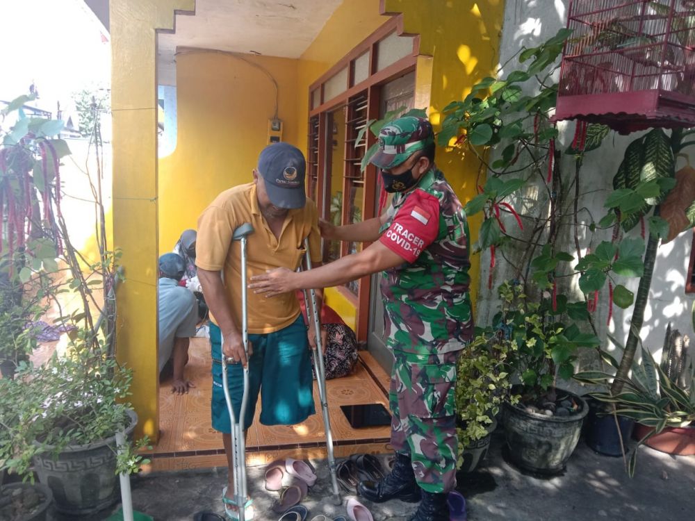 Babinsa Koramil Duduksampeyan saat membantu peserta vaksin