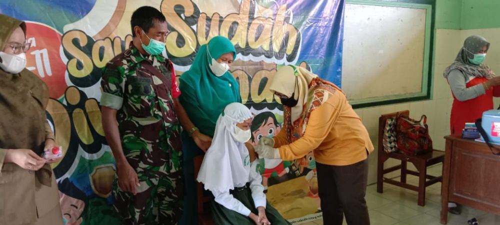 Babinsa Koramil Duduksampeyan saat dampingi vaksin anak