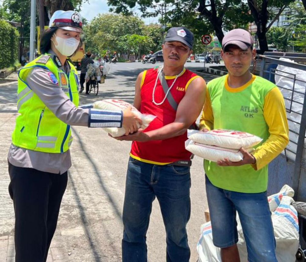 Polwan Polda Jatim saat membagikan paket sembako kepada yang membutuhkan