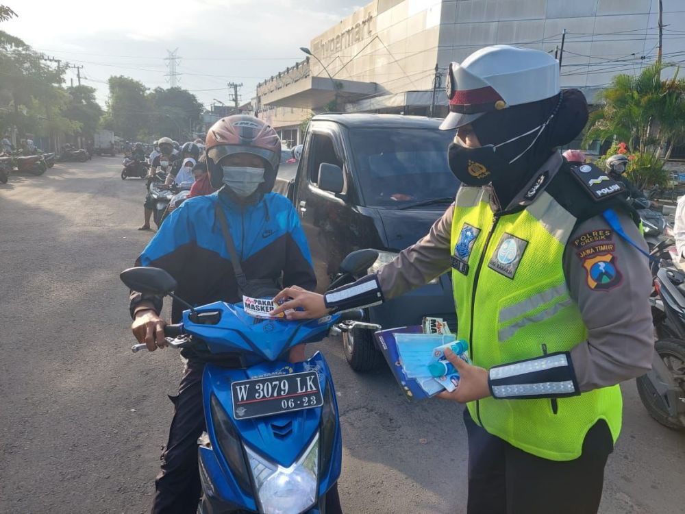 Polwan Polres Gresik saat berbagi masker dan Handsanitizer ke pengendara di Simpang 4 Sidomoro