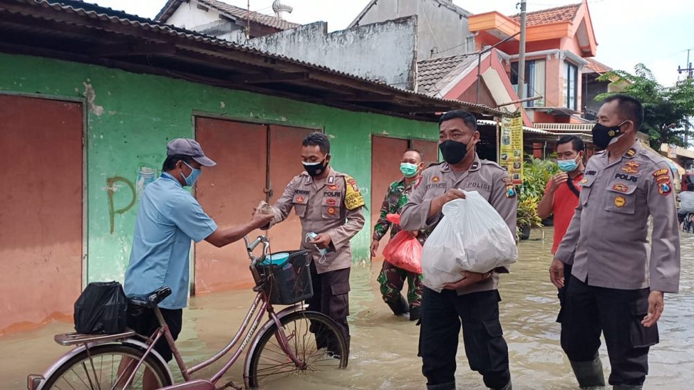 Polisi Gresik saat berbagi makanan ke warga terdampak banjir