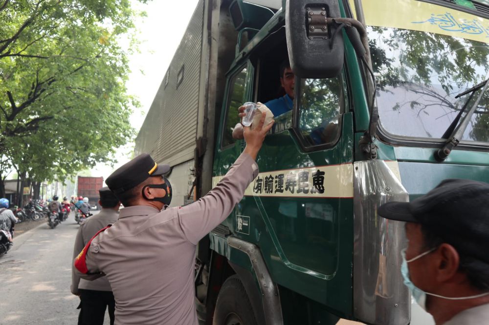 Kapolsek Manyar AKP Windu Priyo Prayitno saat membagikan nasi bungkus dan air mineral
