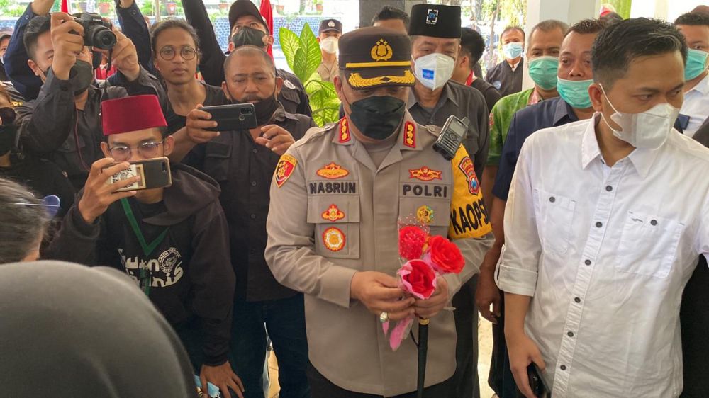 Kapolresta Banyuwangi Kombespol Nasrun Pasaribu saat membagikan bunga