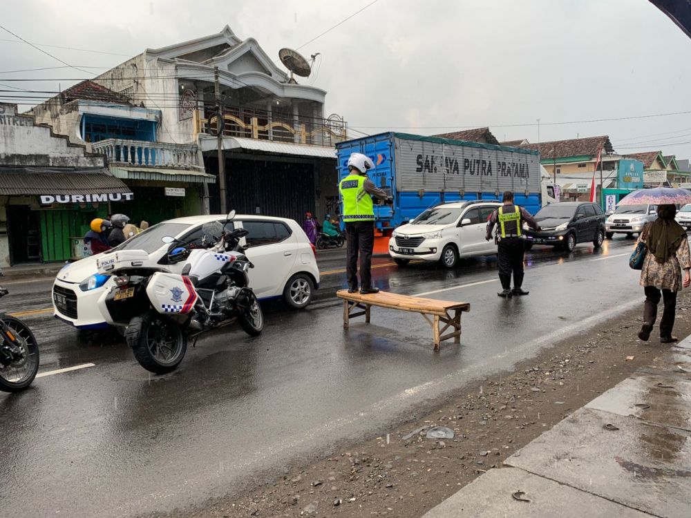 Personil Polres Tulungagung tetap mengatur lalu lintas saat di terpa hujan