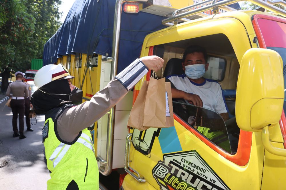 Polantas Polres Pelabuhan Tanjung Perak saat berbagi makanan fokus ke pengendara