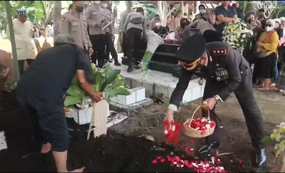 Tampak kyapolres Sumedang menaburkan bunga di atas makam Kompol Ibnu Setiawan setelah prosesi pemakaman.